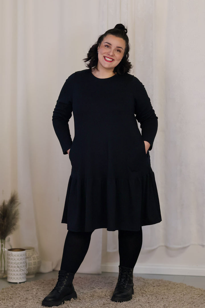 A-linjainen, täysin suomalainen mekko, jossa on taskut ja röyhelöhelma. Kuvassa koko XL.