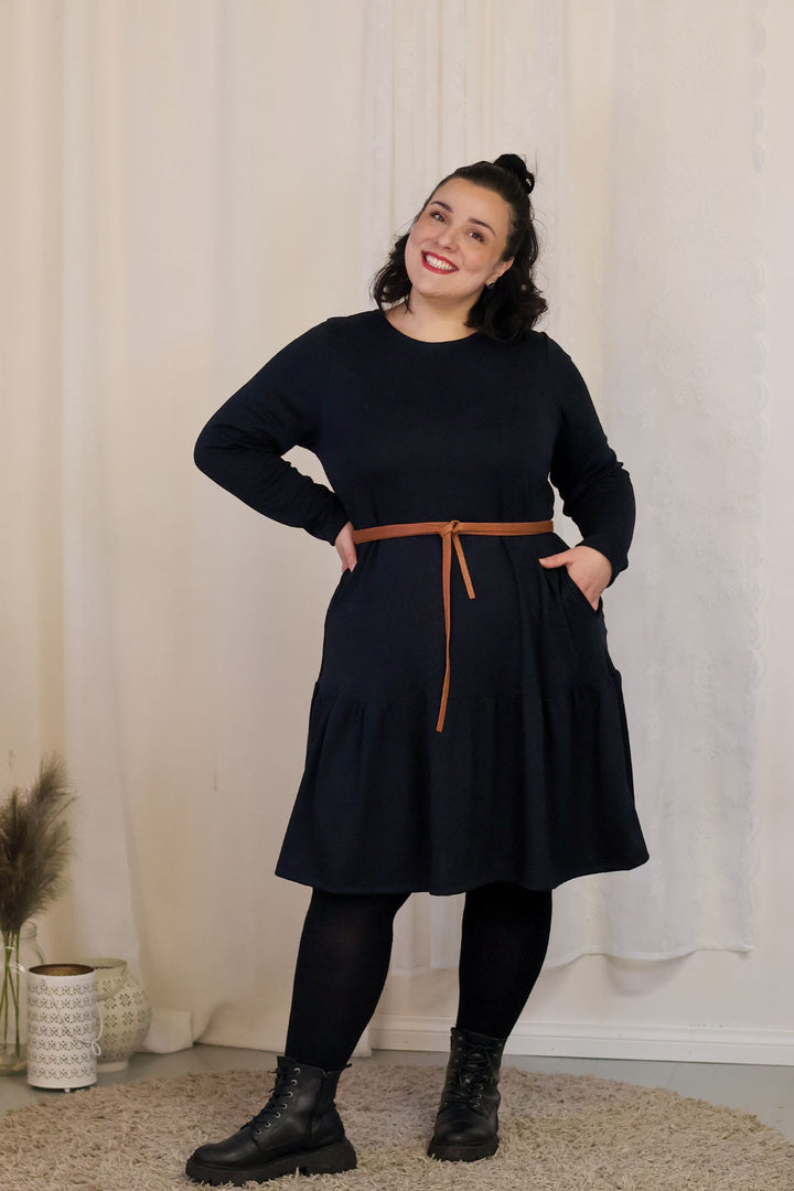 A-linjainen Juni-neulosmekko stailattuna Kiedon kietaisuvyöllä. Mekossa on hauska röyhelöhelma sekä taskut. Mekko on täysin kotimainen ja Suomessa valmistettu.