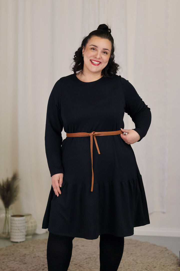 Musta Juni-neulosmekko koossa XL. A-linjainen väljä mekko saa uuden siluetin kun stailaat sen Kiedon kietaisuvyöllä.