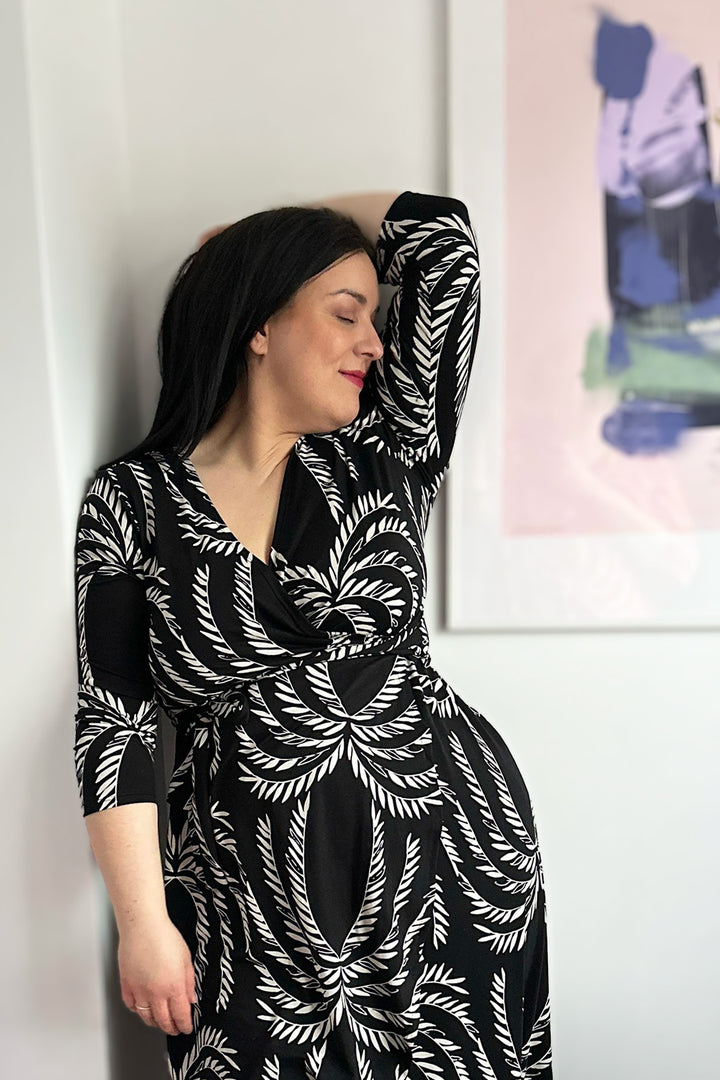 Mustavalkoinen Laura-kietaisumekko Siivet-kuosilla koossa XL. Mekossa on 3/4 pituiset hihat. Kietaisumekko on valmistettu kokonaan Suomessa.